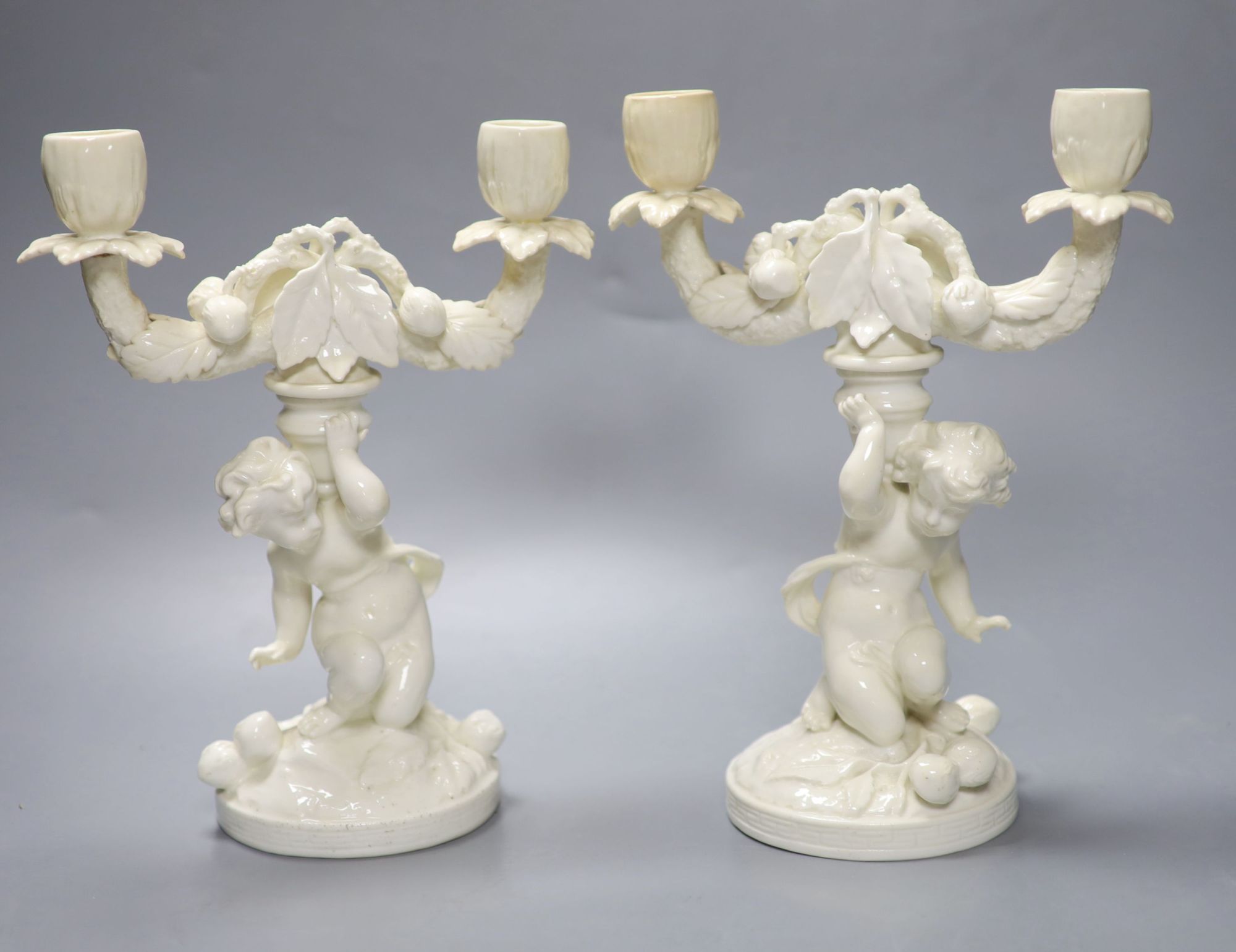 A pair of English bone china cherub candelabra, possibly Moore Bros., height 26cm